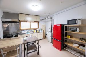 a kitchen with a red refrigerator and a table at Tomoeドットコム3 music stay in Hakodate