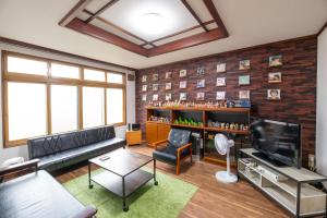 a living room with a couch and a television at Tomoeドットコム3 music stay in Hakodate