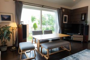 a living room with a table and chairs and a television at FredHouse東川 in Higashikawa