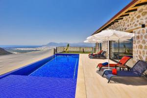 ein Swimmingpool mit Stühlen und einem Sonnenschirm in der Unterkunft Villa kırlangıç in Kaş