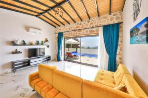 ein Wohnzimmer mit Couch und Fernseher in der Unterkunft Villa kırlangıç in Kaş