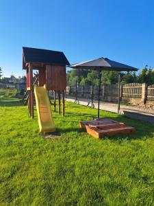 a playground with a table and an umbrella at Apartamenty u Anety in Wilkasy