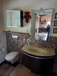 a bathroom with a sink and a toilet and a mirror at Ca' d Licio - Attico in Polinago +15 photos
