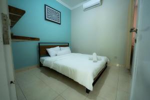 a bedroom with a bed with a white bedspread at House Shizen I in Uluwatu