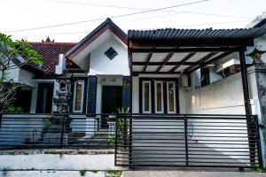 a white house with a black fence in front of it at House Shizen I in Uluwatu