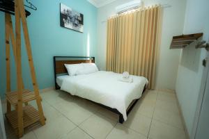a bedroom with a white bed and a wooden ladder at House Shizen I in Uluwatu