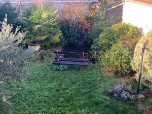 a park bench sitting in the middle of a garden at Charmant studio terrasse 25min Aéroport CDG in Saint-Brice-sous-Forêt +4 photos