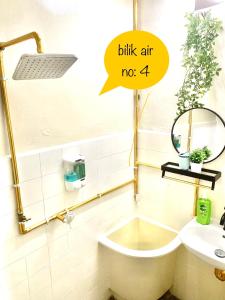 a bathroom with a sink and a tub and a mirror at Nadialisa cottage homestay For Islamic only in Sungai Petani
