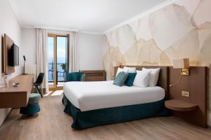 una camera d'albergo con un letto e una scrivania di Hotel Le Rive a Nyon