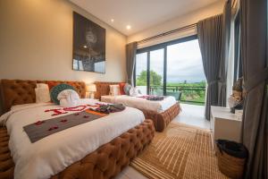 una camera d'albergo con due letti e una grande finestra di Cavara Villa Canggu a Canggu Altre 75 foto