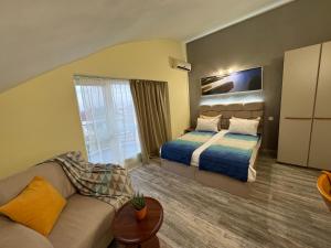 a hotel room with a bed and a couch at Family hotel Neptun - Lozenets in Lozenets