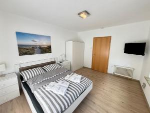 a bedroom with a bed and a flat screen tv at Ferienhaus zur Knock in Emden