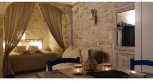 a bedroom with a bed and a table with chairs at Casa Mirabilis 44 in Ostuni