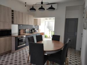 a kitchen with a wooden table and chairs at Villa Maris Stella à 250m de la plage de Petit Fort Philippe in Gravelines