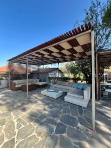 a pergola with couches and tables on a patio at Villa Terrina in Áyioi Apóstoloi +19 photos