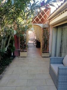 une passerelle menant à une maison avec une terrasse dans l'établissement petite maison avec jardin calme, au Thor