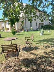 two chairs and a table in front of a house at BeB montefratta in Fratta Terme