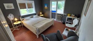 een slaapkamer met een bed en twee stoelen en twee ramen bij Guestrooms at Forest Family Home in Ytterhogdal