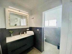 a bathroom with a sink and a mirror and a shower at IV Apartamentos Morales & Arnal in Ronda +19 photos