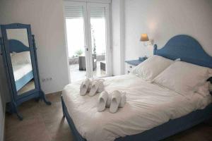 a bedroom with a bed with two slippers on it at X C Apartamentos Morales & Arnal in Ronda
