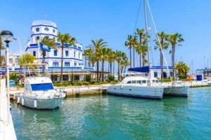 three boats docked in a marina in front of a building at XV Apartamentos Morales & Arnal in Estepona