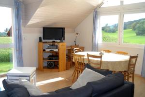 uma sala de estar com um sofá e uma mesa com uma televisão em Appartment Aux Lilas em Les Geneveys-sur-Coffrane