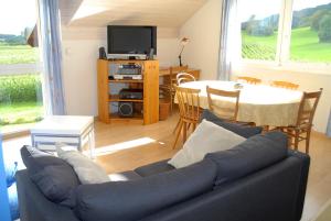 sala de estar con sofá y mesa en Appartment Aux Lilas, en Les Geneveys-sur-Coffrane
