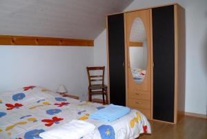a bedroom with a bed and a dresser and a mirror at Appartment Aux Lilas in Les Geneveys-sur-Coffrane