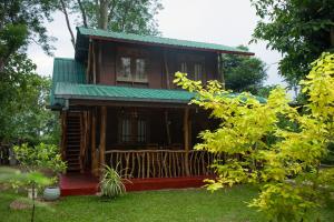 a small wooden house with a green roof at Thought Blooming in Udawalawe