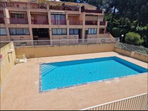 une grande piscine devant un bâtiment dans l'établissement Studio piscine, proche mer, parking privé, à Bandol