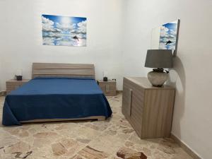 a bedroom with a bed and a night stand with a lamp at Casa di Pippo in Trappeto