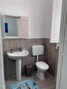 a bathroom with a sink and a toilet and a mirror at Casa di Pippo in Trappeto