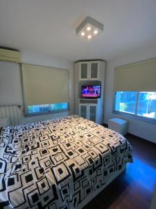 a bedroom with a large bed and a television at Moderno piso con vista al río en zona residencial in San Nicolás de los Arroyos