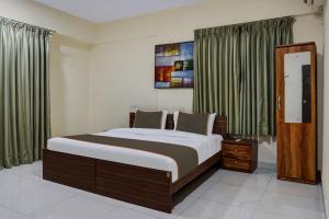 a bedroom with a large bed with green curtains at Hotel O Grandeur in Méribel Village
