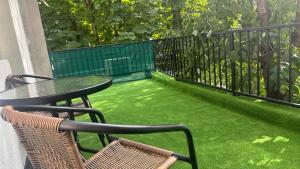 a table and chairs on a balcony with green grass at Sweet Apartament in Baia Mare +5 photos