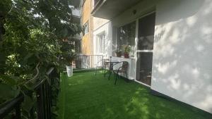 a balcony with green grass and a table and chairs at Sweet Apartament in Baia Mare