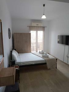 a bedroom with a large bed with a window at Ascension Corfu Studios by GuestCorfu in Análipsis
