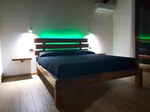 a bedroom with a bed with green lights on it at Nova Rooms in Gonnesa