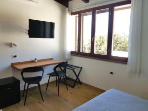 a room with a table and two chairs and a tv at Nova Rooms in Gonnesa