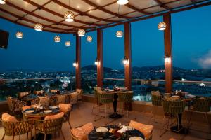 a restaurant with tables and chairs with a view at Regenta Central Udaipur, Court Circle in Udaipur