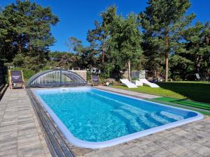 a swimming pool with a bridge in a yard at Apartamenty-Baltivia in Hel