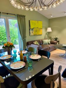 ein Wohnzimmer mit einem Tisch mit Stühlen und einer Couch in der Unterkunft Villa Collina, freistehendes Haus mit Garten und Seezugang in Scheid