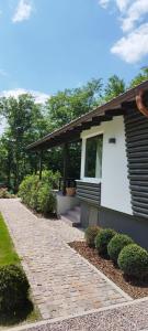 ein Haus mit einem Backsteinsteg neben einem Gebäude in der Unterkunft Villa Collina, freistehendes Haus mit Garten und Seezugang in Scheid