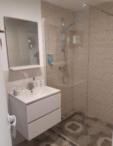 a bathroom with a sink and a glass shower at Căsuțele de vară in Vişeu de Sus