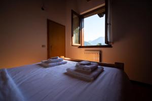 a bedroom with a bed with towels on it at Appartamenti Lembondel - Ledro in Tiarno di Sotto +57 photos