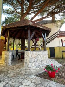 a wooden gazebo with a table under a tree at Apartments Villa-G Lustica in Tivat
