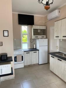 a kitchen with white appliances and white cabinets at Vázsonyi Vendégház in Balatonfüred