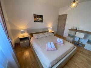 a bedroom with a bed with two flip flops on it at Apartman Žuki in Pirovac