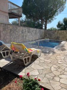 two lounge chairs sitting next to a swimming pool at Apartments Villa-G Lustica in Tivat