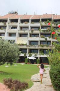 a woman standing in front of a large apartment building at Cimer SafraMarine Beach Resort in Safra